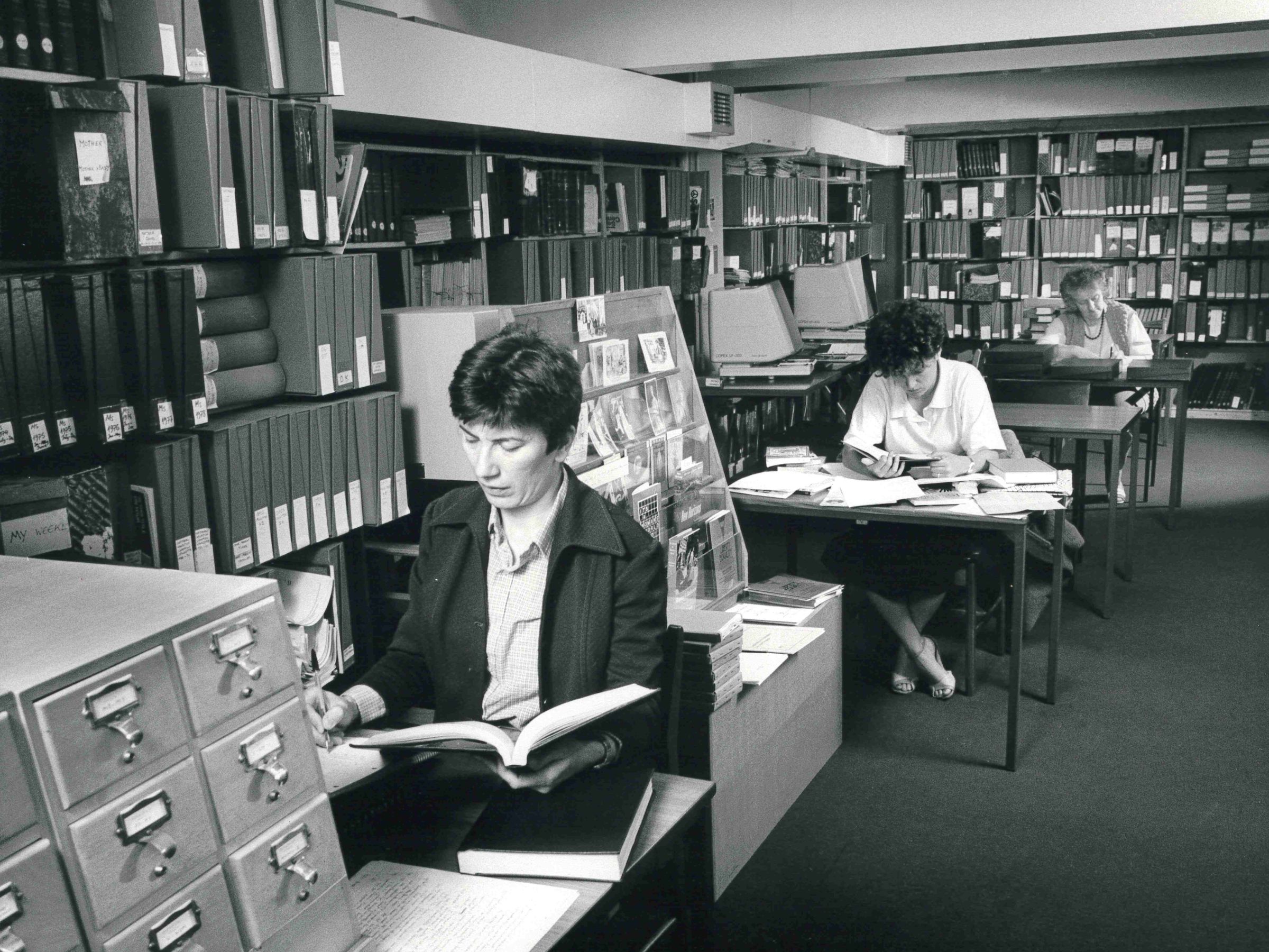 People sitting at individual desks doing research.
