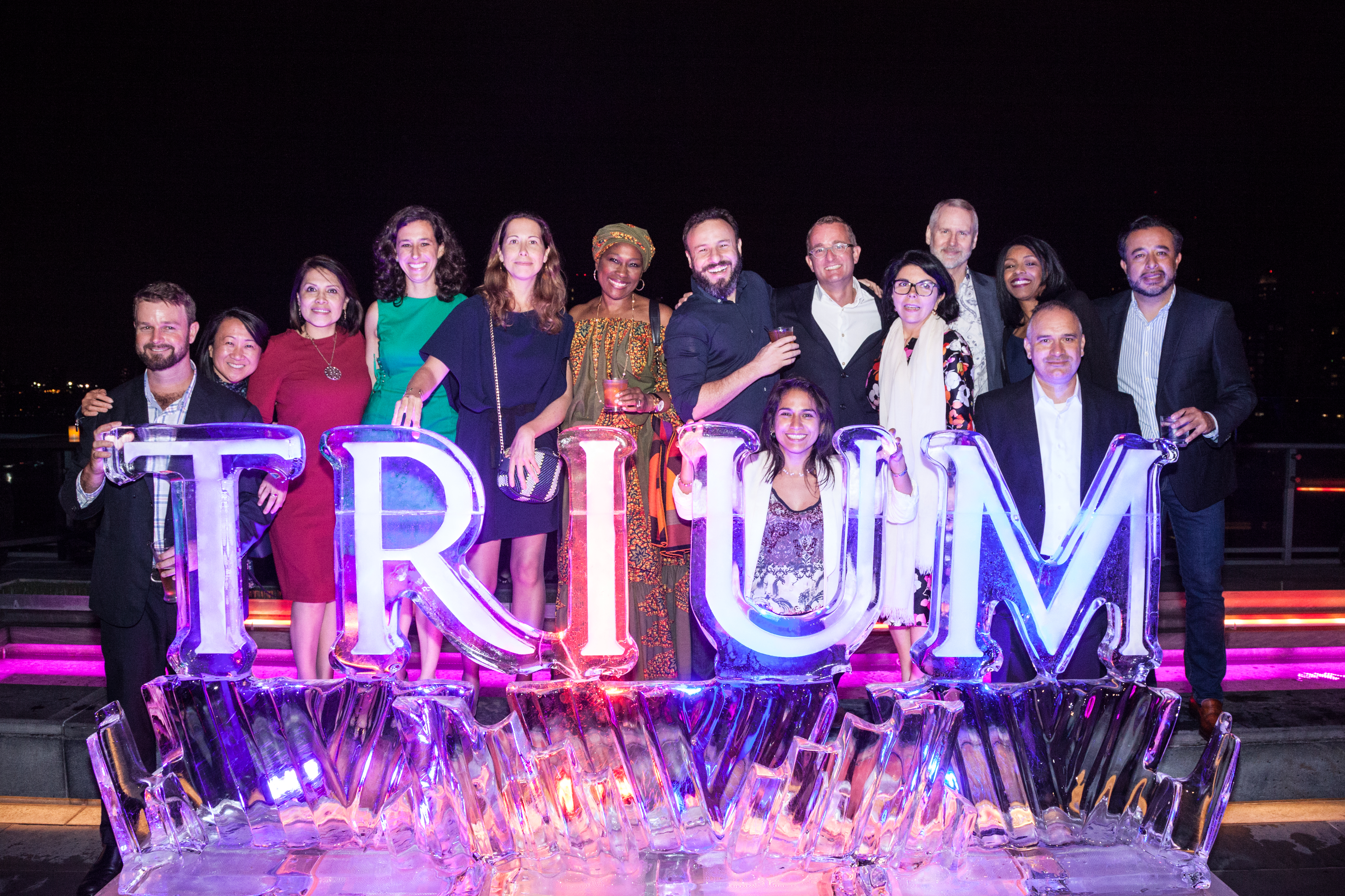 Staff with a sign reading TRIUM