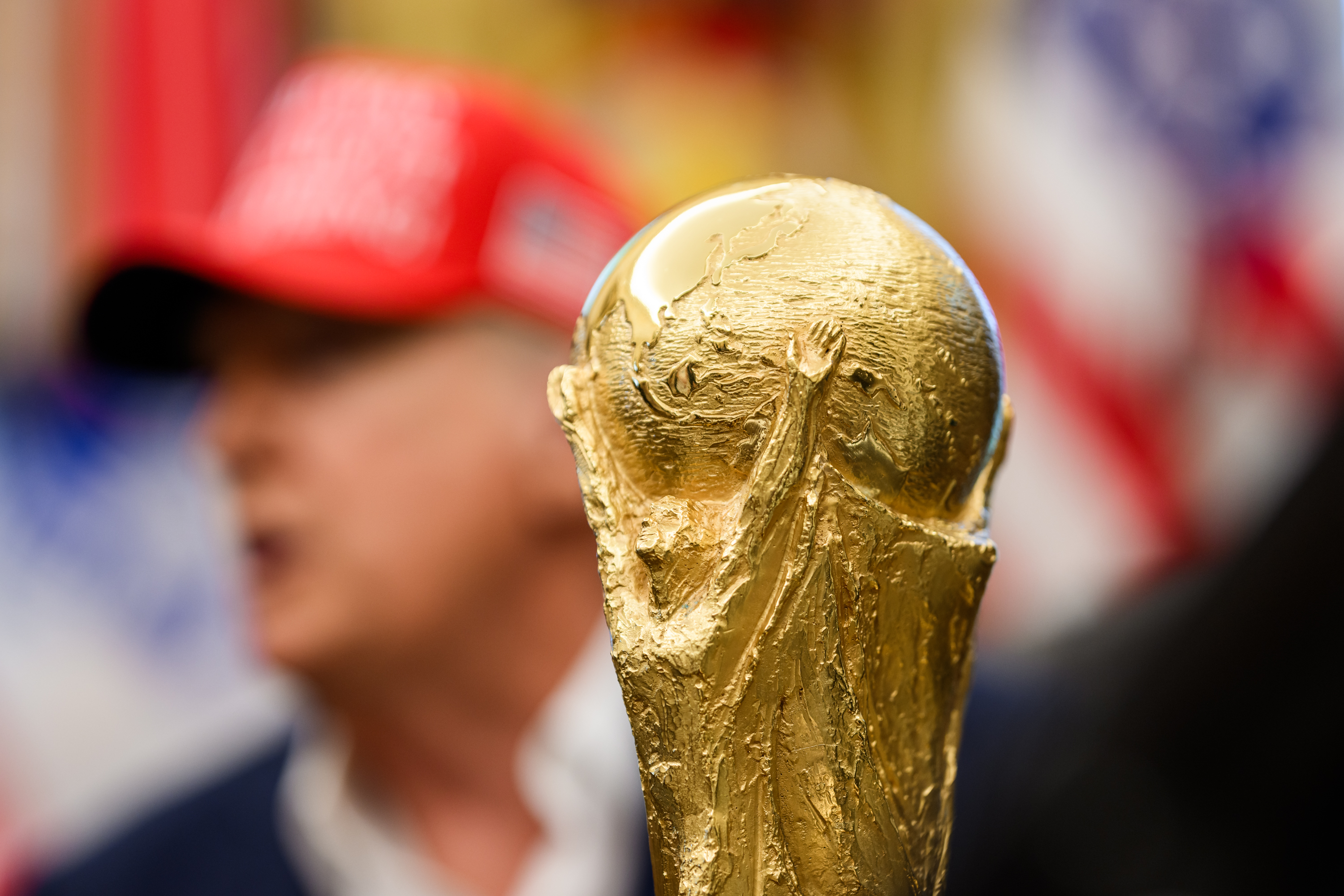 The 2026 World Cup trophy, with President Trump behind it