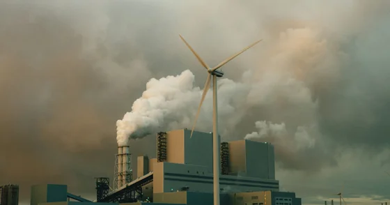 a factory with smoke billowing out of it's stacks
