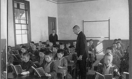 A school room showing children reading overseen by teachers, Japan