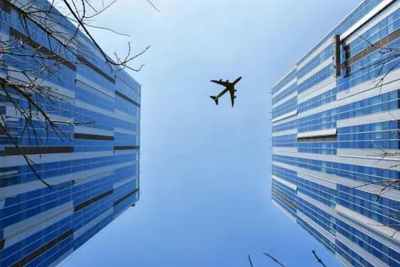 Aeroplane flying between high rise buildings