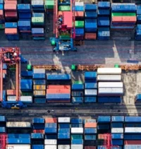 Shipping containers are piled up near a dock
