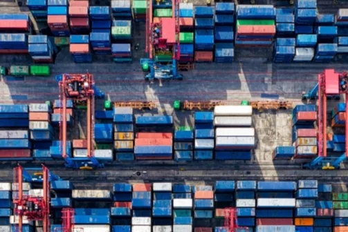 Shipping containers are piled up near a dock