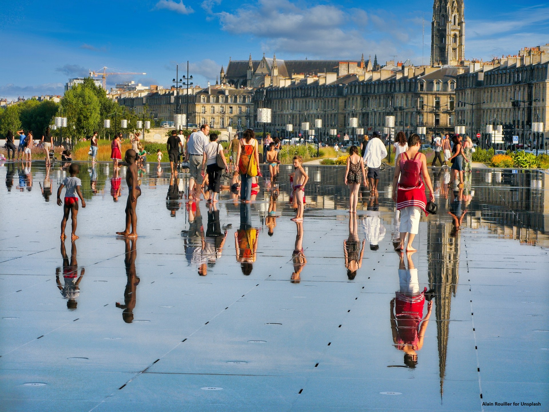 People walk barefoot on a water installation in central Bordeaux.