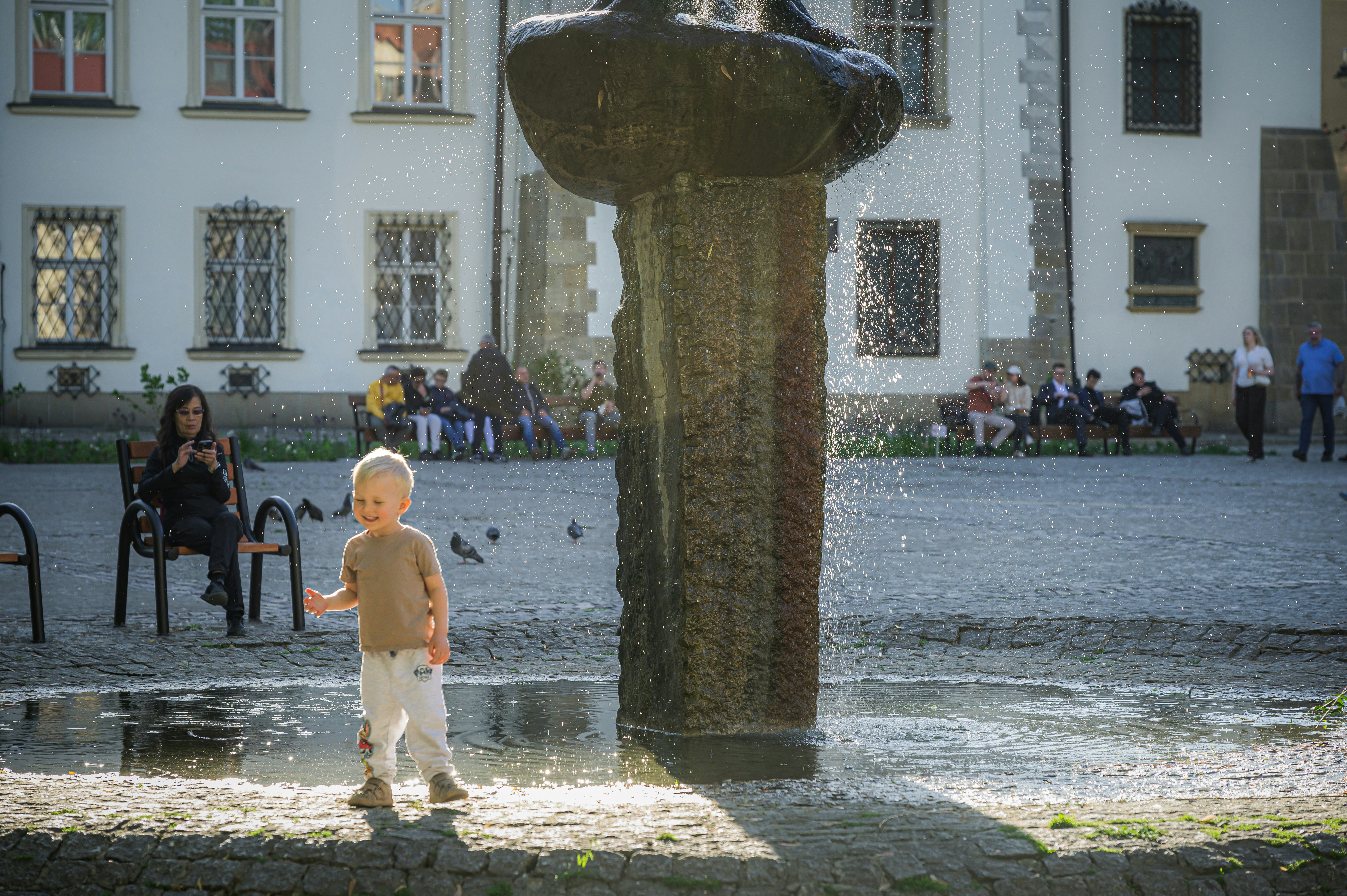 Child playing next to water fountain