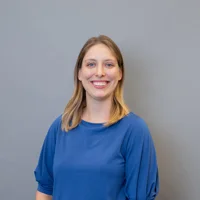 Allie Bobak is wearing a blue top and smiling. She has shoulder-length blonde hair.