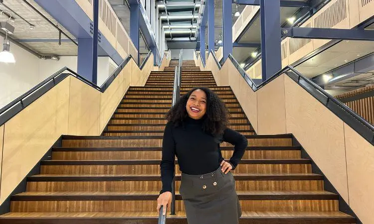 Alumna Abadesi Osunsade standing on stairs in Centre Building