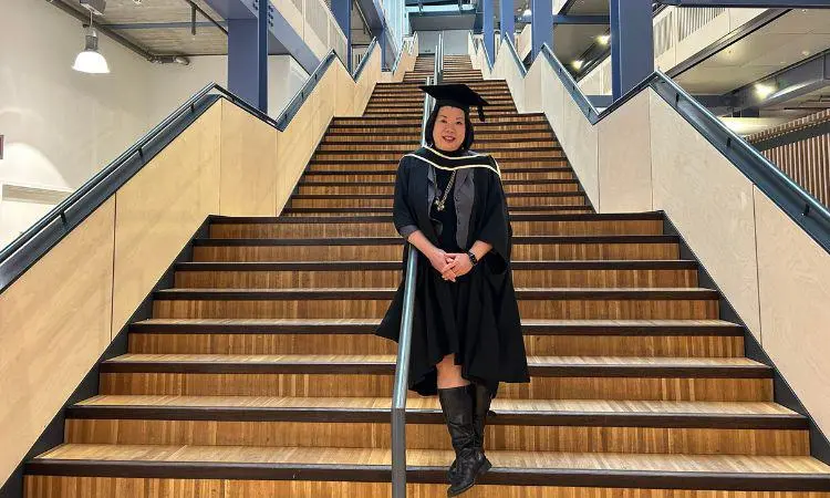 Alumna Jenny Chong standing on stairs in Centre Building