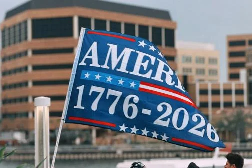 A blue flag with the words "America 1776-2026"