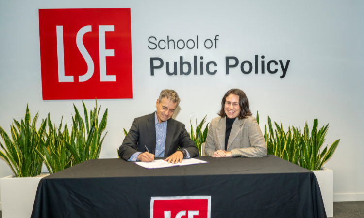 Professor Velasco signing the renewal agreement with Isabella Luksic smiling