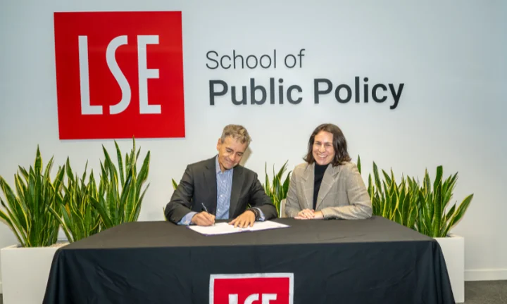 Professor Velasco signing the renewal agreement with Isabella Luksic smiling
