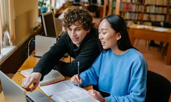 two students studying at laptop