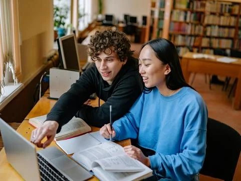 two students studying at laptop