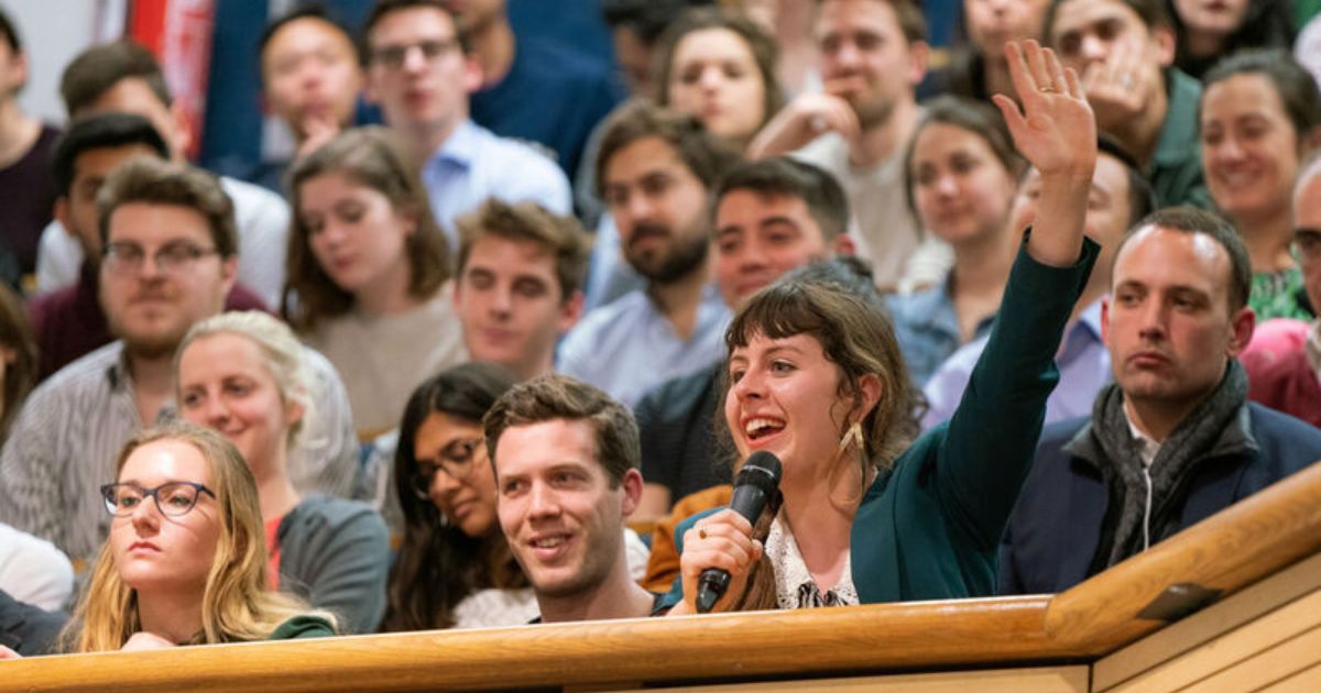 An audience member raises their hand to ask a question at an LSE public event