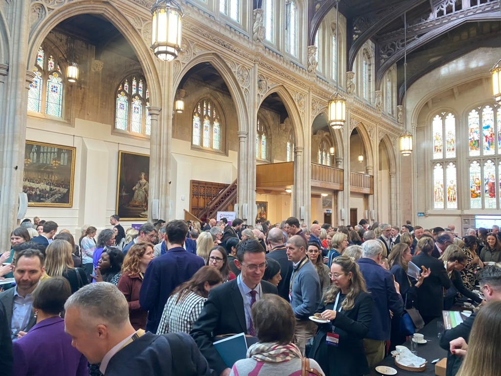 People standing in a grand hall networking at a conference