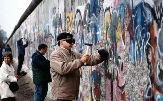 A person chiselling the Berlin Wall