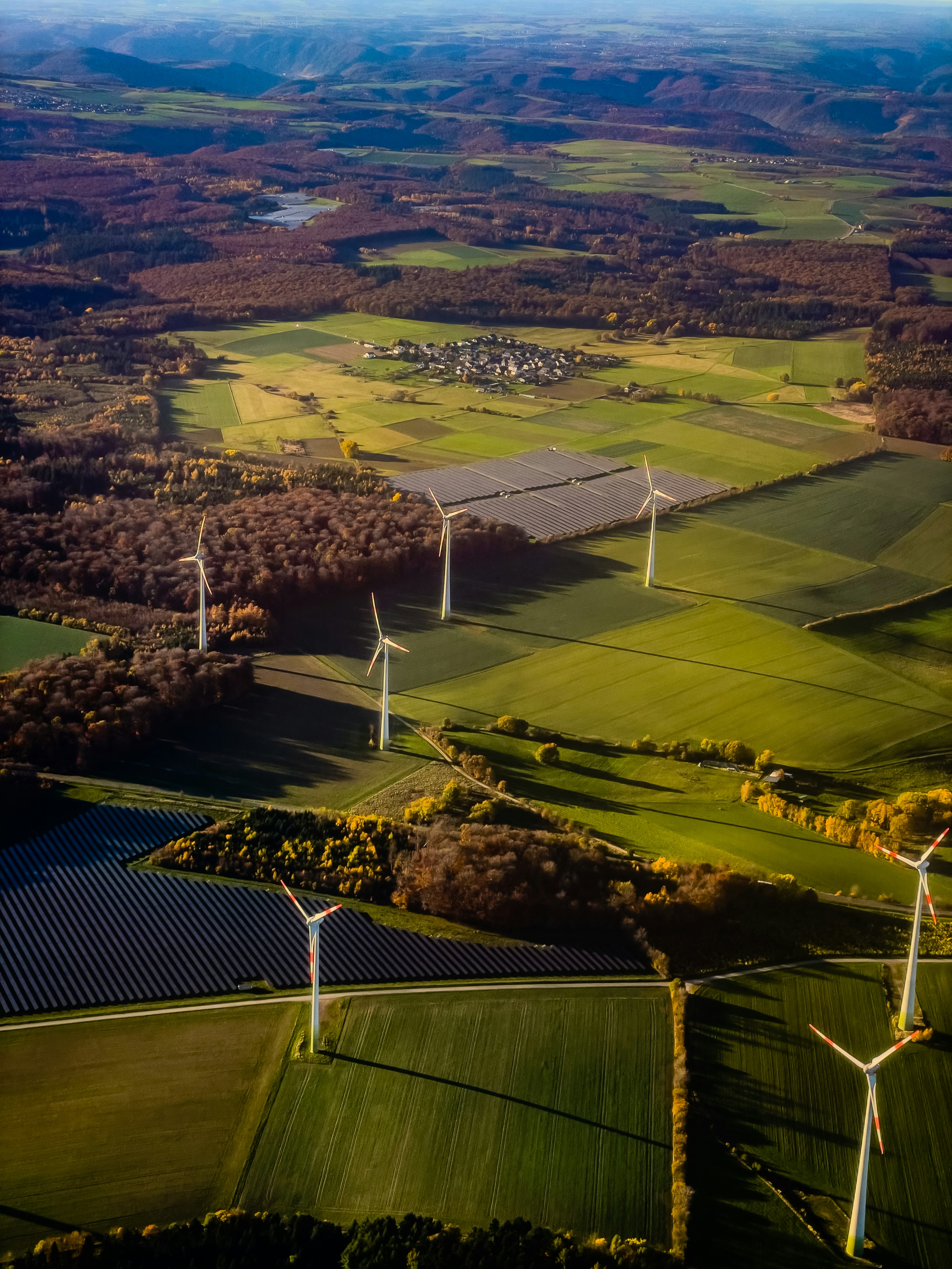 Aerial shot of fields with wind turbines and solar panels on
