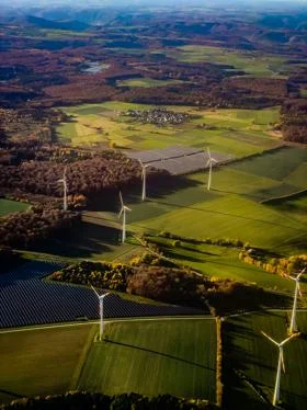 Aerial shot of fields with wind turbines and solar panels on