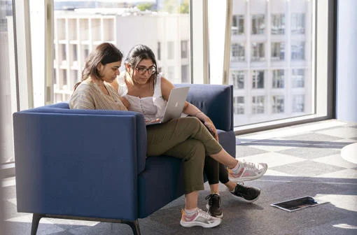 Two students in Centre Building looking at a laptop