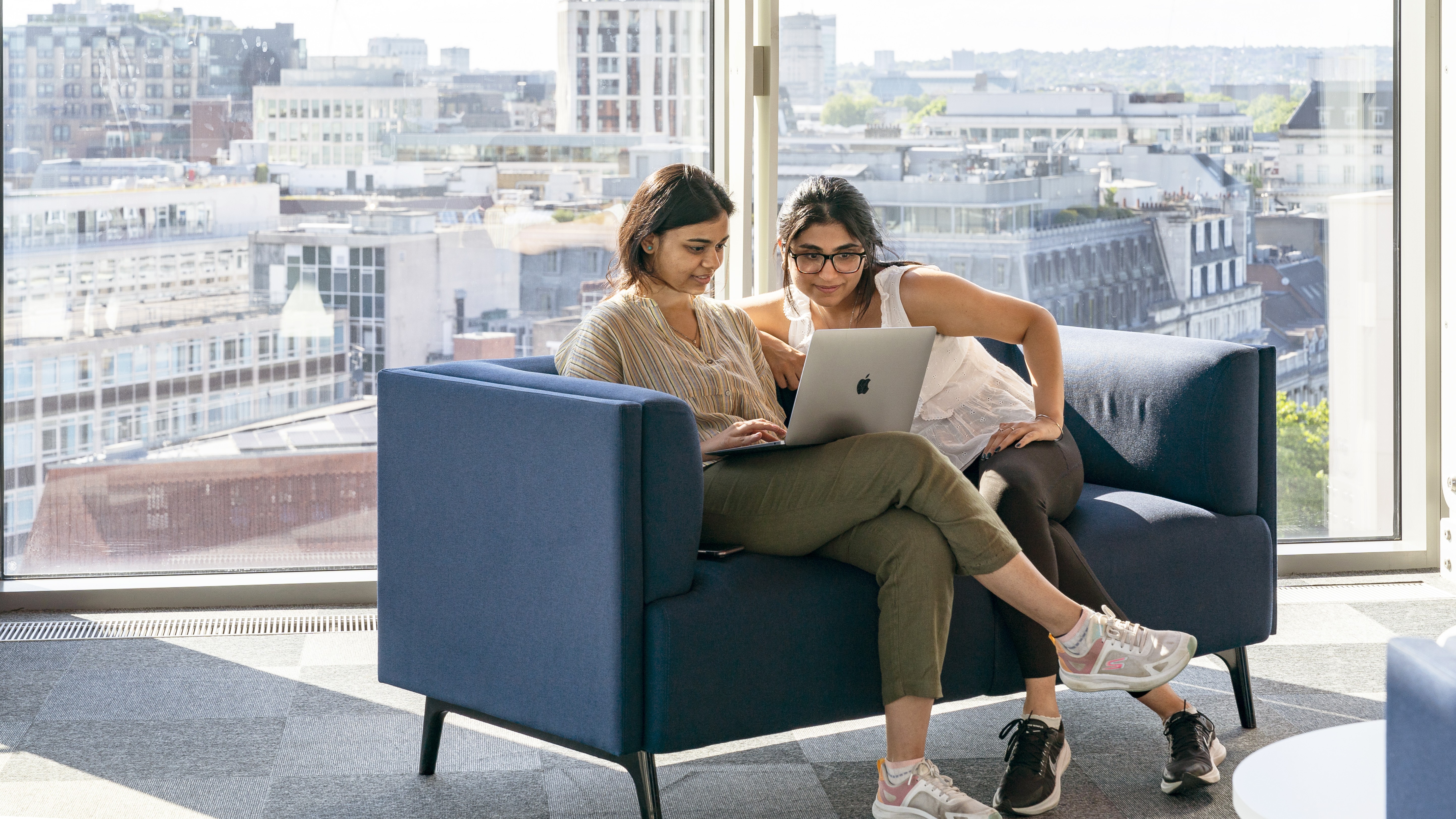 Two students looking at a laptop