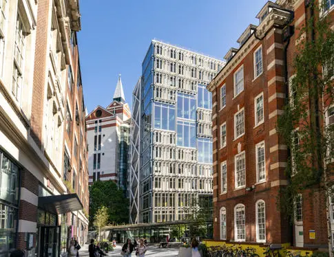 LSE Library plaza, facing the Centre Building on a sunny day. Students walking across plaza.