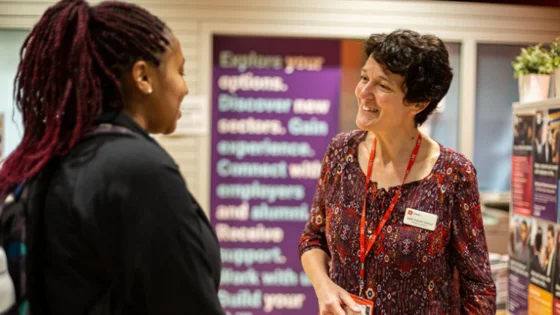 Two women speaking at a careers fair