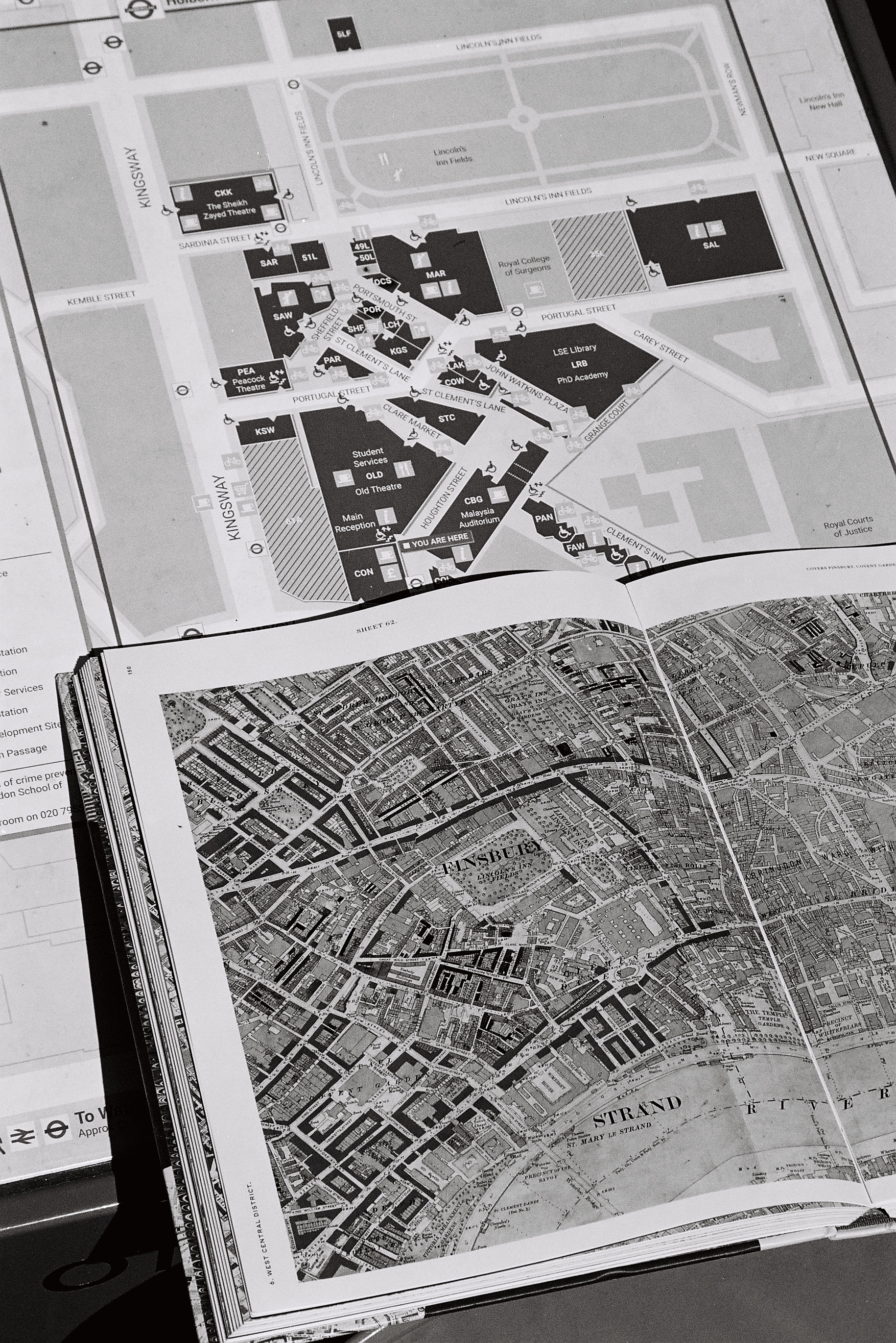 old map in front of new campus map