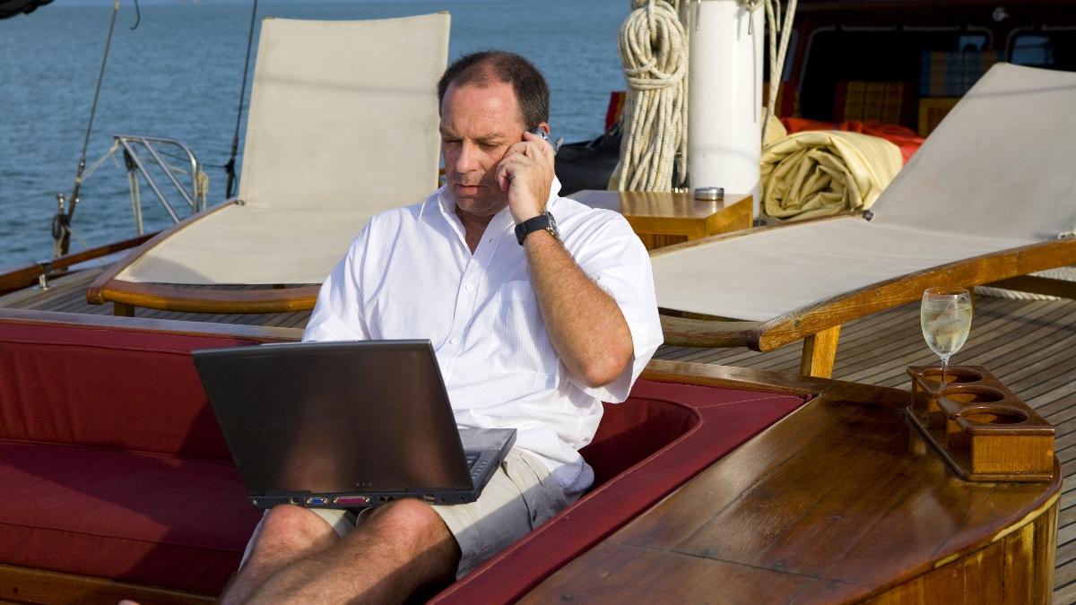 Person on a mobile phone sitting on a yacht