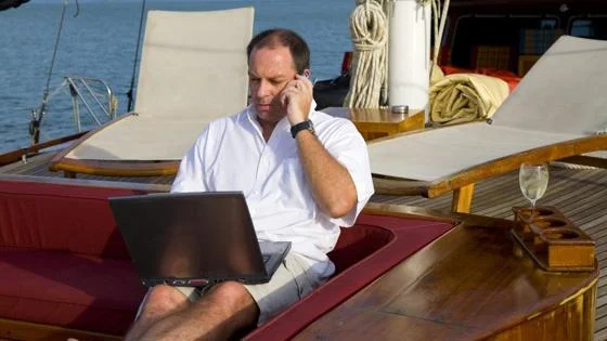 Person on a mobile phone sitting on a yacht