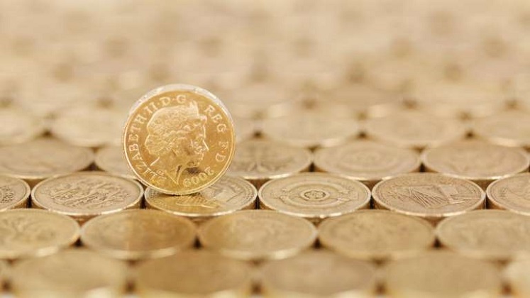 Pound coins lying flat and one on edge