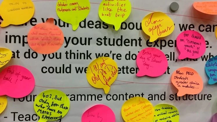 poster covered with postit notes with student feedback