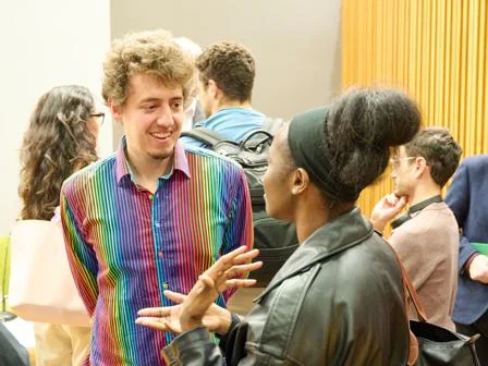 Dr Dario Krpan talking to student at event.