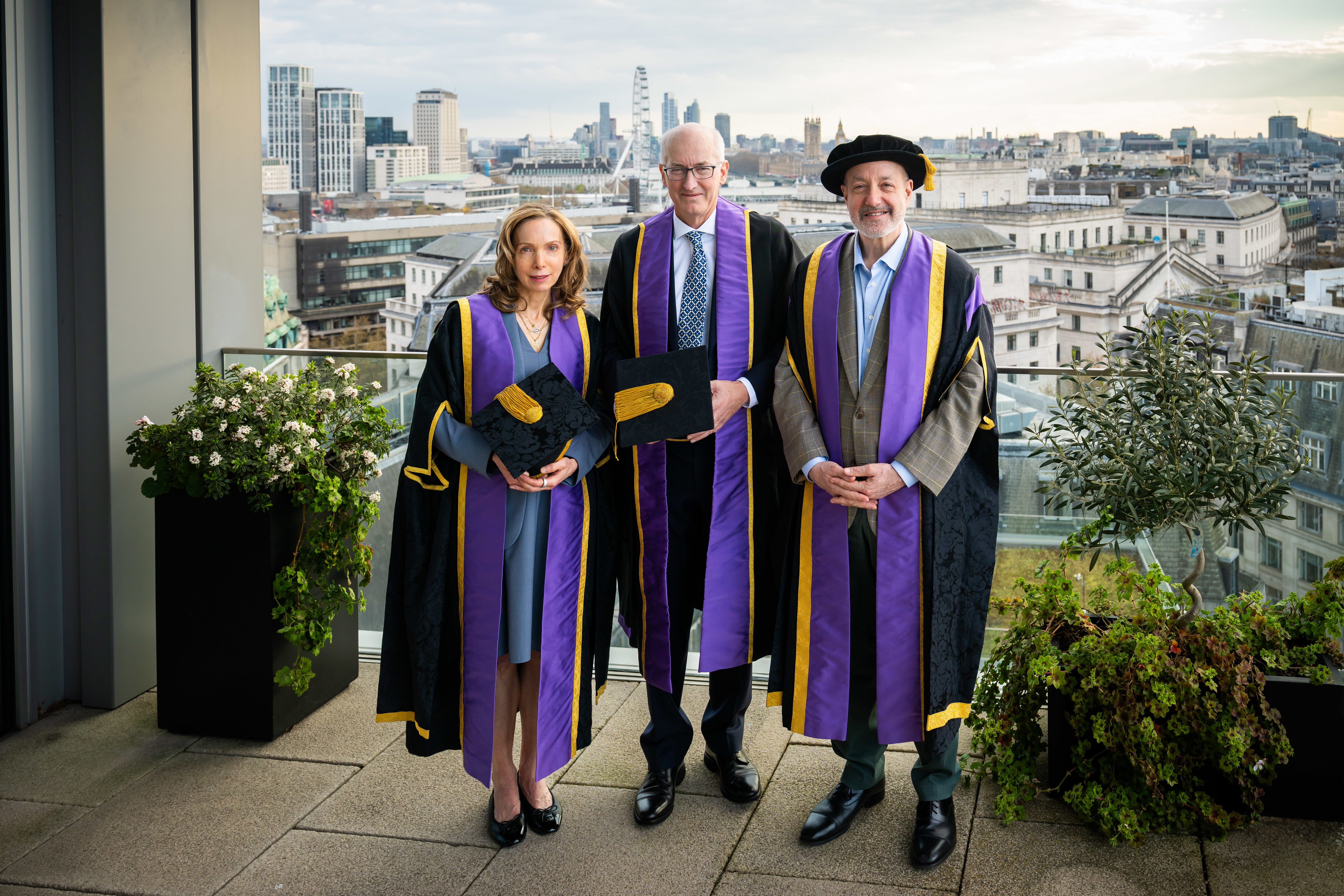 Susan Liautaud, David Higgins and Larry Kramer stand left to right with the London skyline in the background.