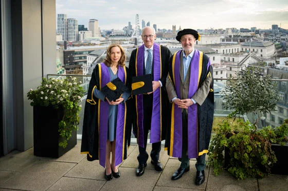 Susan Liautaud, David Higgins and Larry Kramer stand left to right with the London skyline in the background.