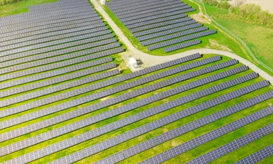 A green field filled with solar panels in lines