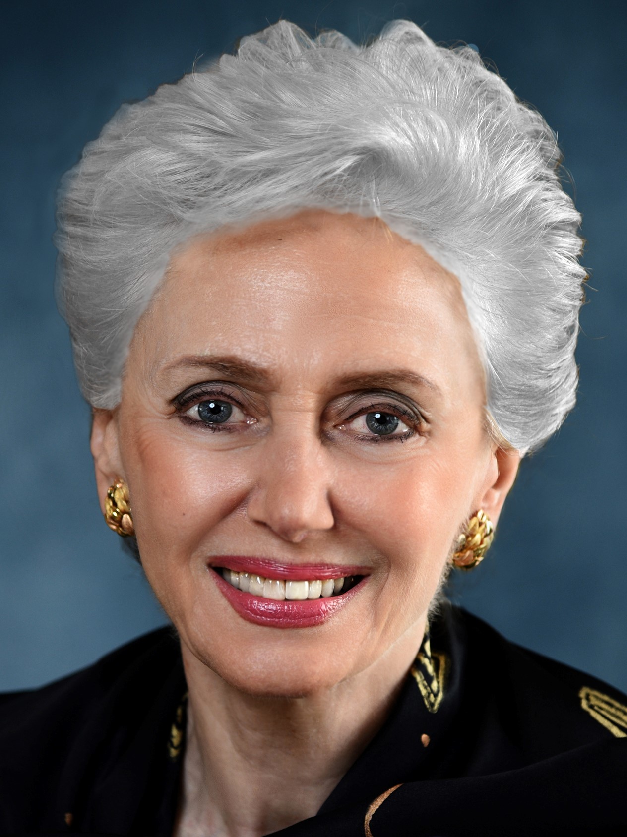 The image is of Georgette Bennett, an academic with white hair and gold earrings. 