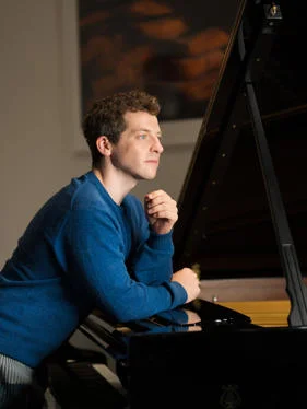 Henry Kramer leaning on piano