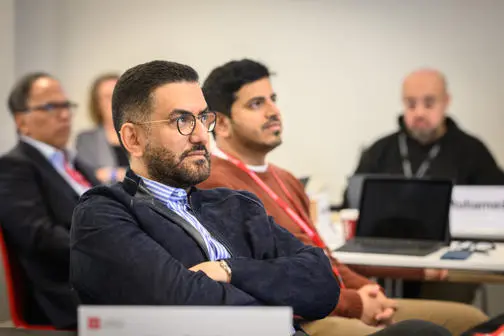 Man with glasses and arms crossed looks on
