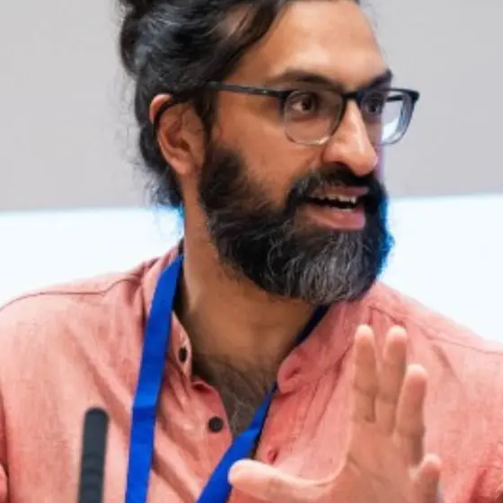 Man wearing lanyard gesturing while speaking