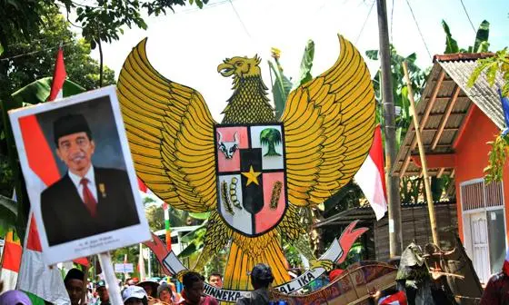 People gathered in the street, holding national symbols and images of former President Joko Widodo