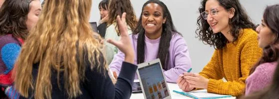 students seated around a table, laptops open