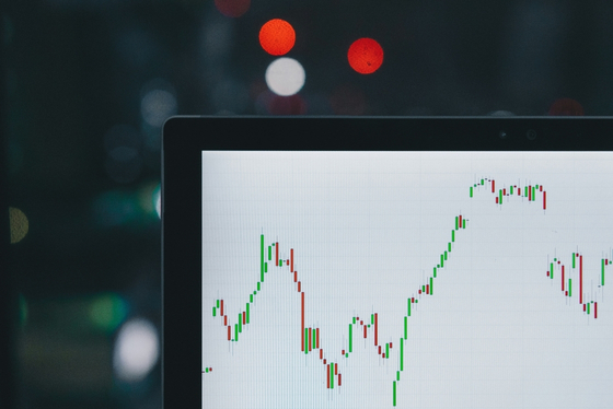 Financial market charts displayed on a laptop screen.
