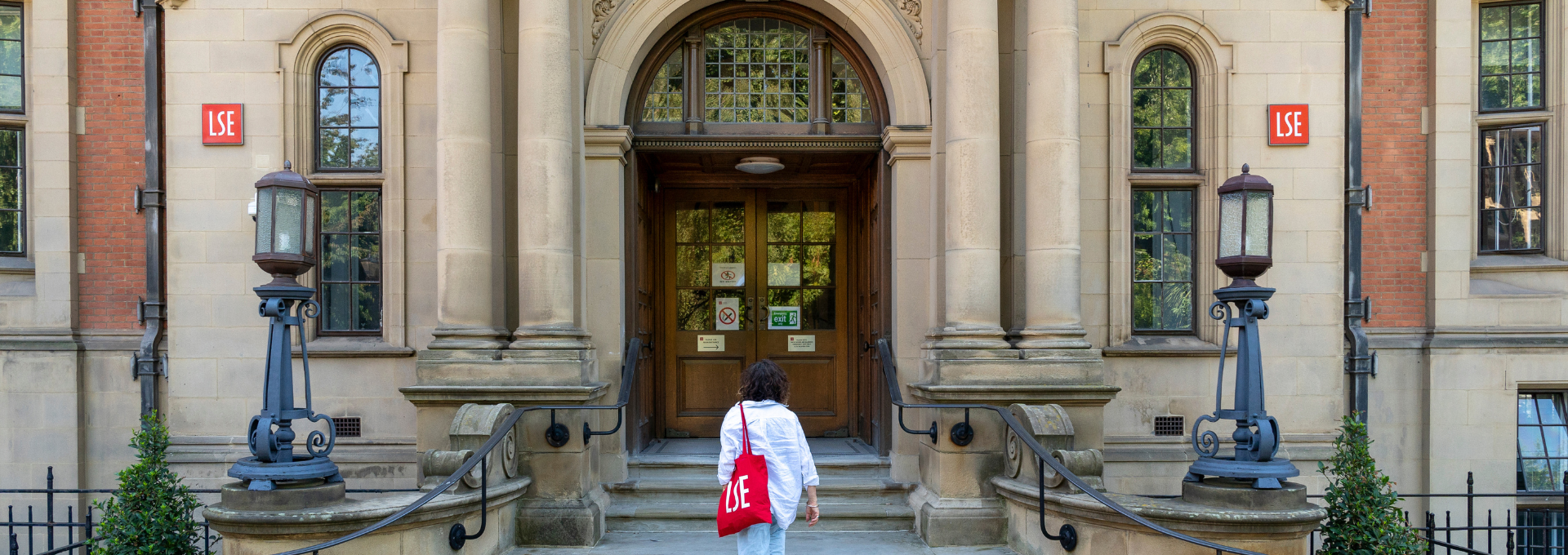 A person with an LSE tote bag outside the Sir Arthur Lewis Building, home of economics at LSE