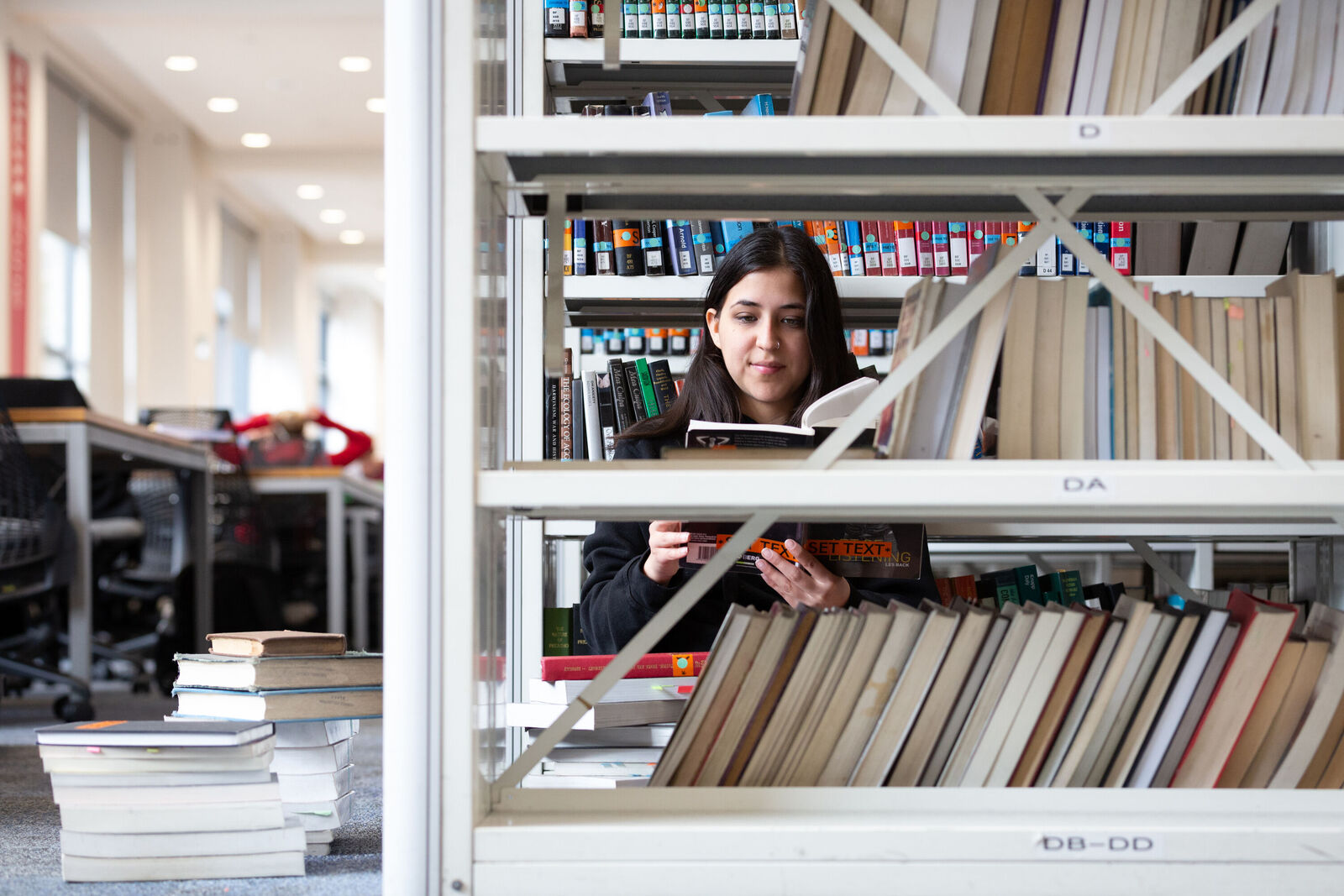 LSE student looking at book in LSE Library