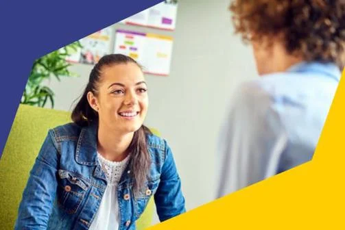 Smiling woman listens to counsellor with EGI student identity branding