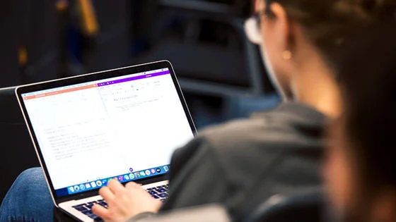 student typing on laptop