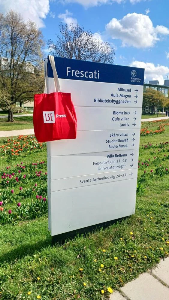 A photo of an LSE Press tote bag hanging on a campus sign at SSE.