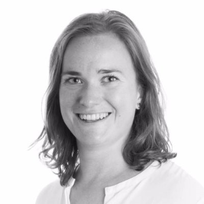 Black and white photo of Emilie. She is smiling and wearing a white top.