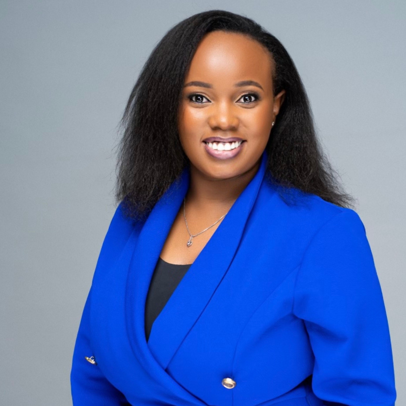 Headshot of woman wearing a blue blazer smiling at the camera.